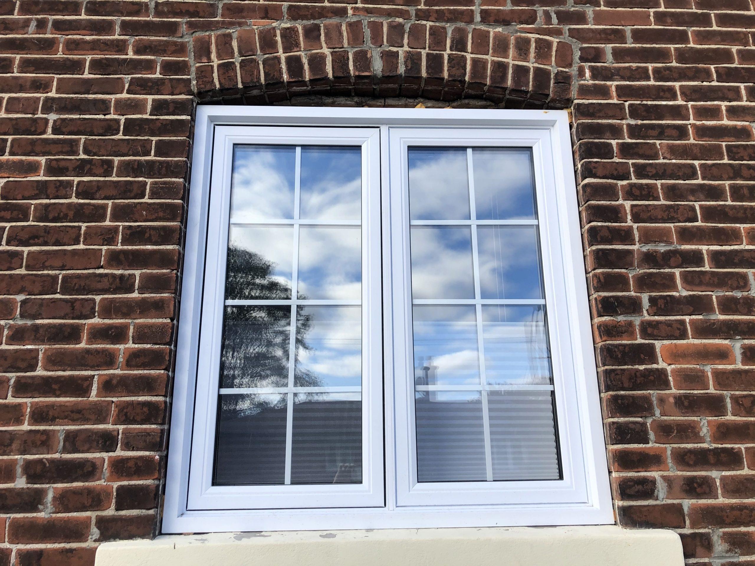 Modern white window in Toronto brick house with new energy-efficient exterior insulation.